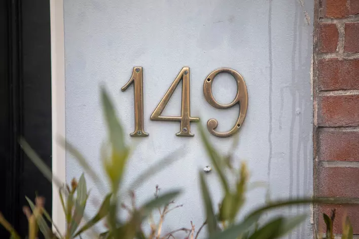 The house numbers on a home that look dirty and tarnished and in need of an upgrade.