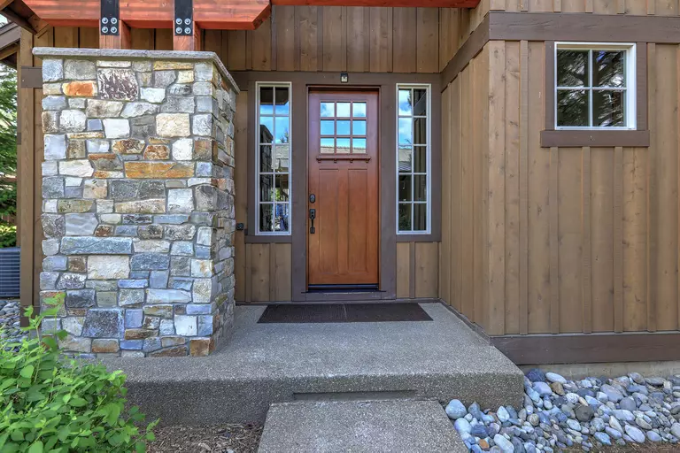 A new woodgrain finish fiberglass door on a log cabin home that keeps the home’s original rustic look.