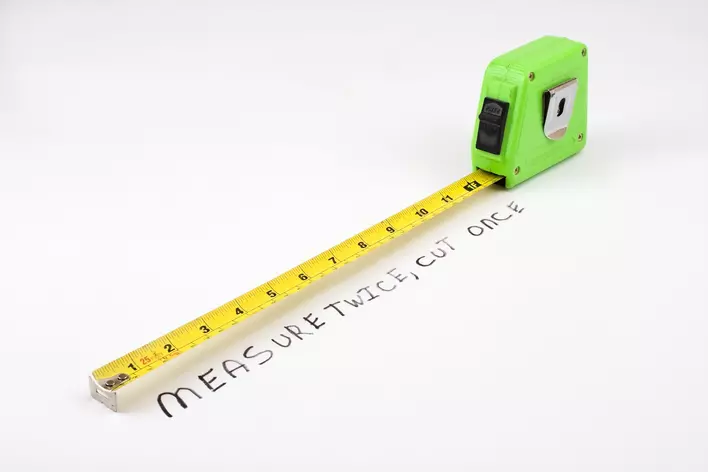 measuring tape with the words measure twice, cut once underneath it