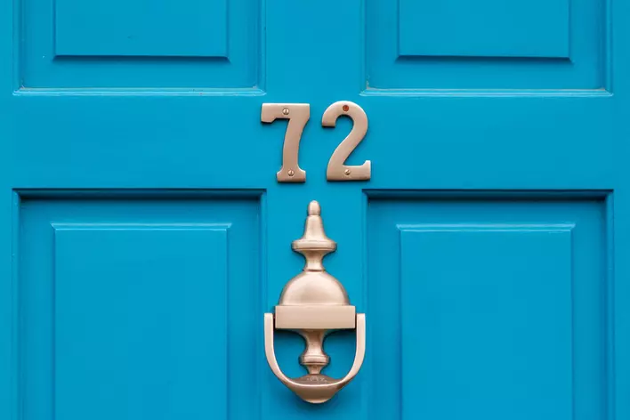 a blue front door with the number “72”