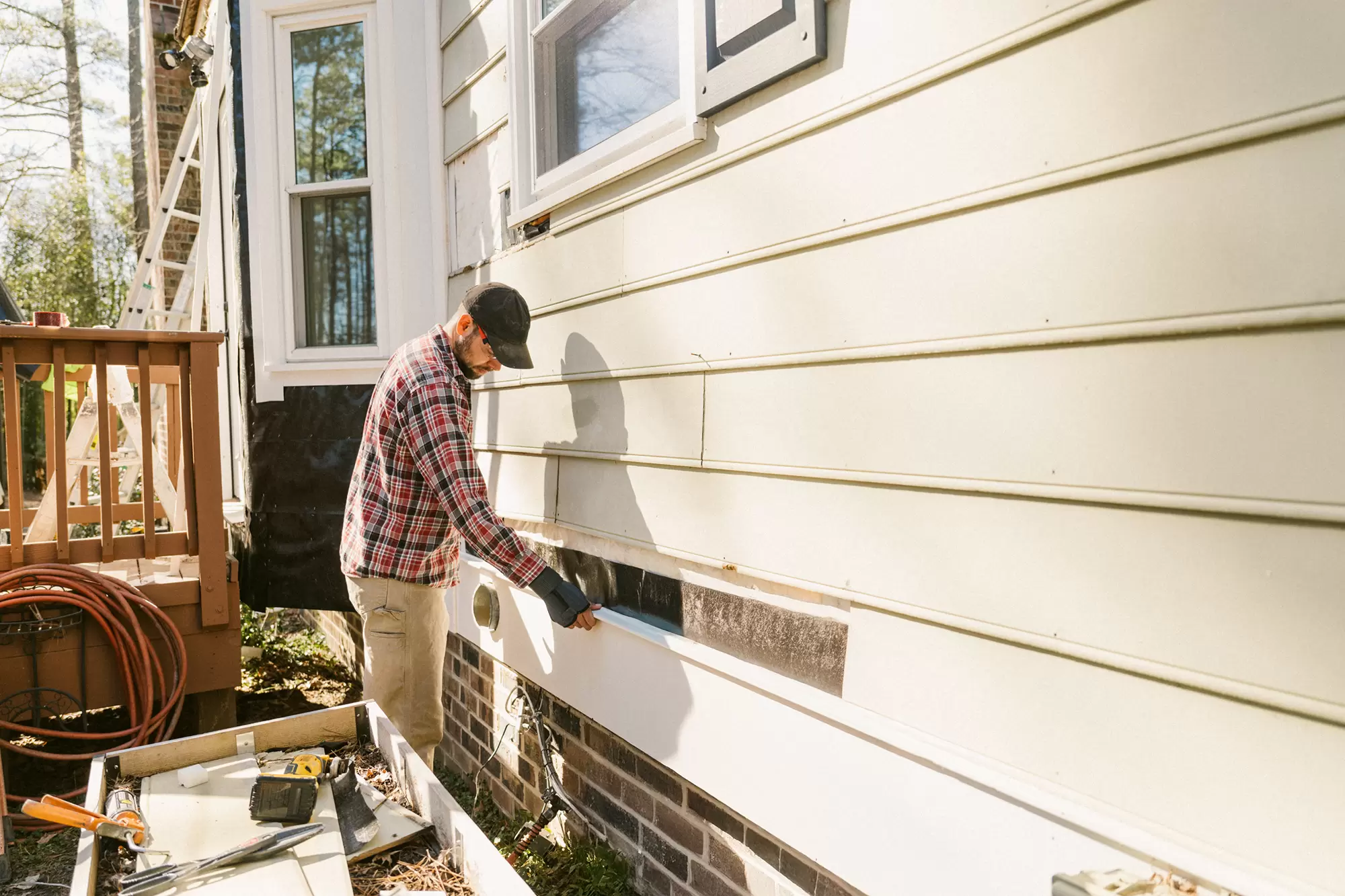 Worker completing a siding project.
