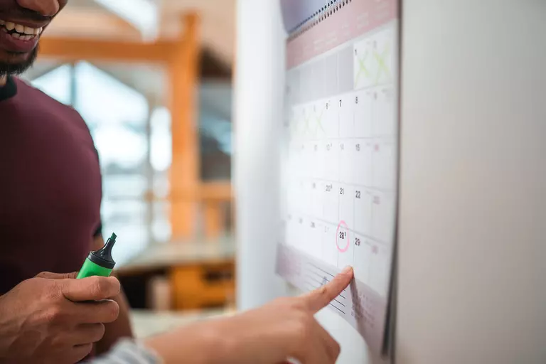 Two people reviewing a calendar.