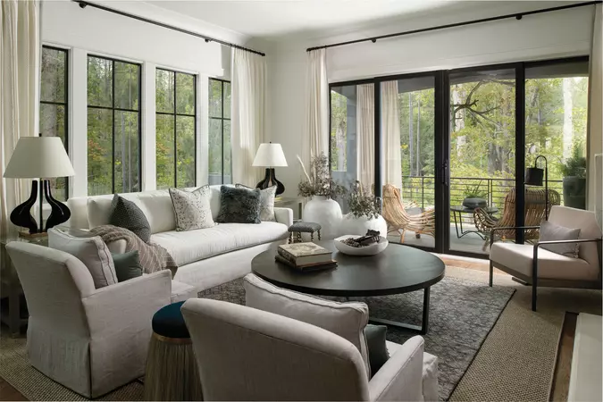 A living room with a black bi-parting sliding patio door connecting to a covered porch.