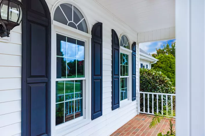 A white house with blue exterior window shutters