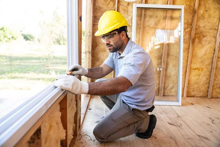Construction worker installing windows on a new house.
