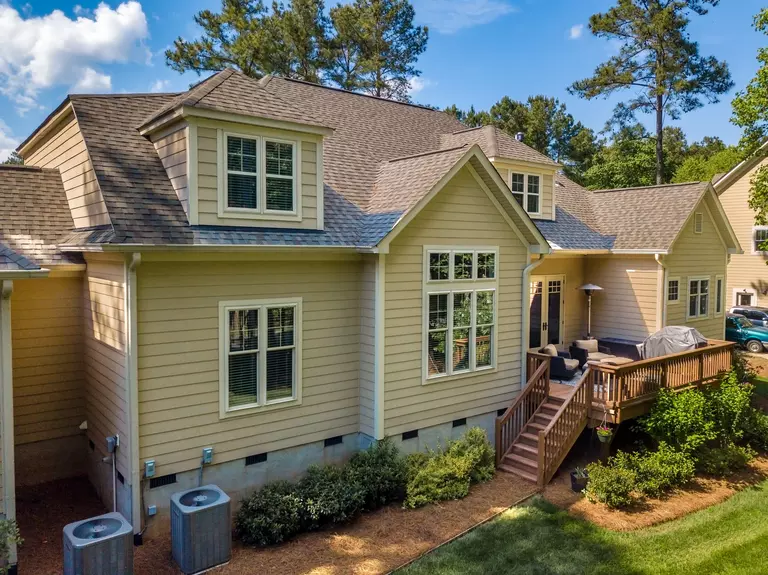 Back exterior of a home with new replacement windows after a storm.