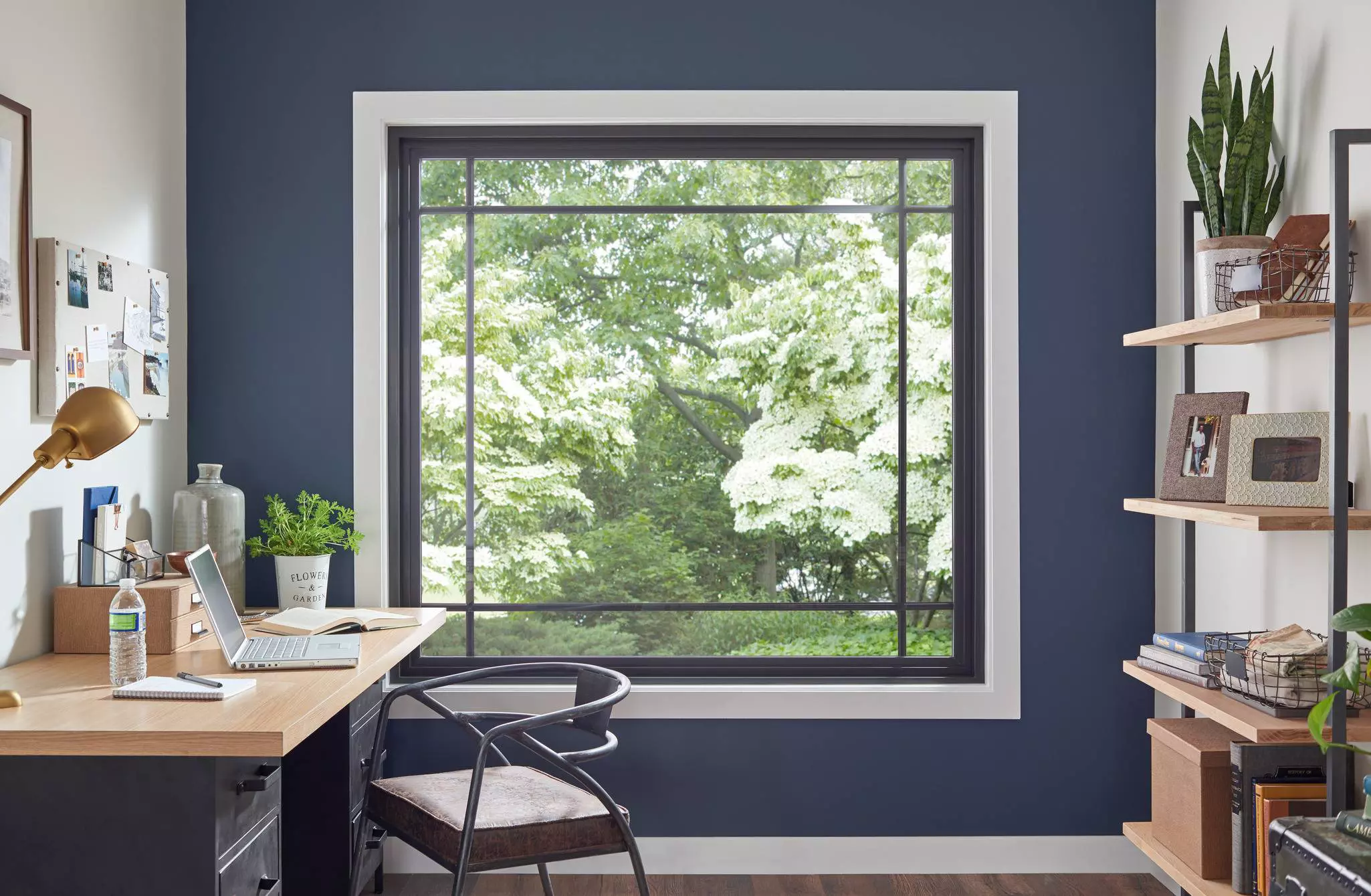 Fixed picture window framing a tree view in a home office.