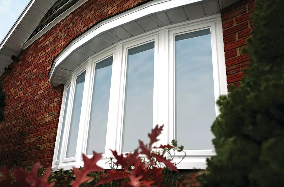 Brick exterior of a home with a bow window.