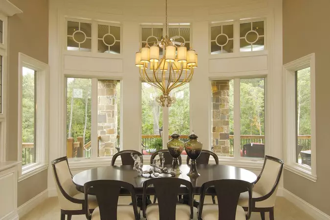 White interior wood-clad casement & awning windows in a dinning room with a dark brown table