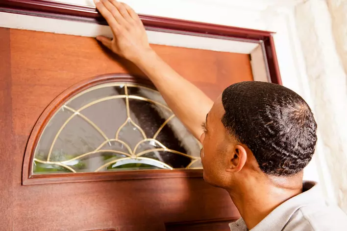 Man investigating the entry door of his home following recent installation.