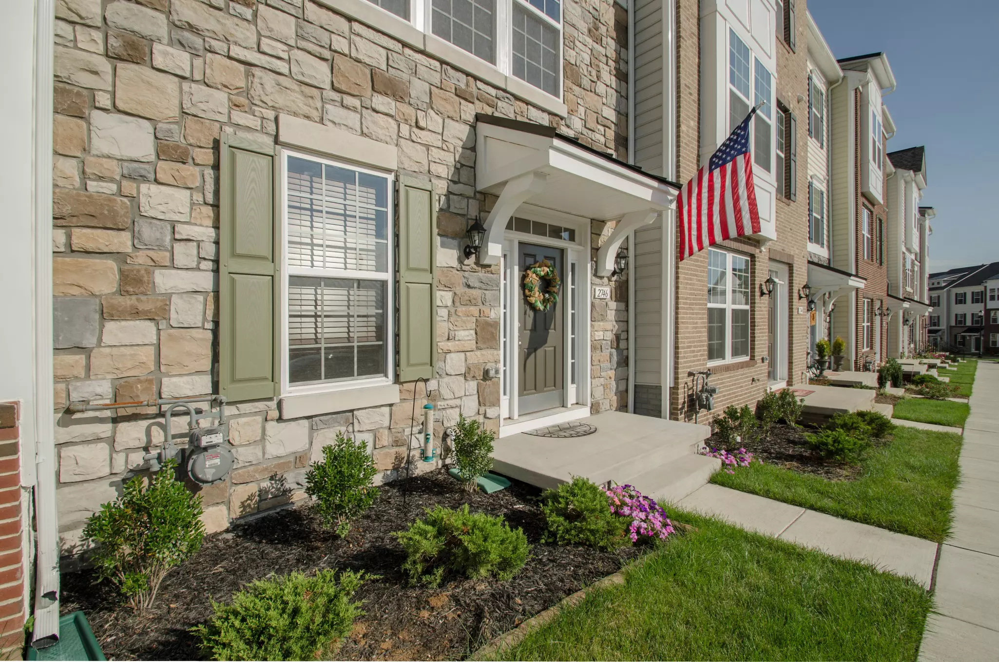 Stone townhouse with east-facing windows and an American flag.