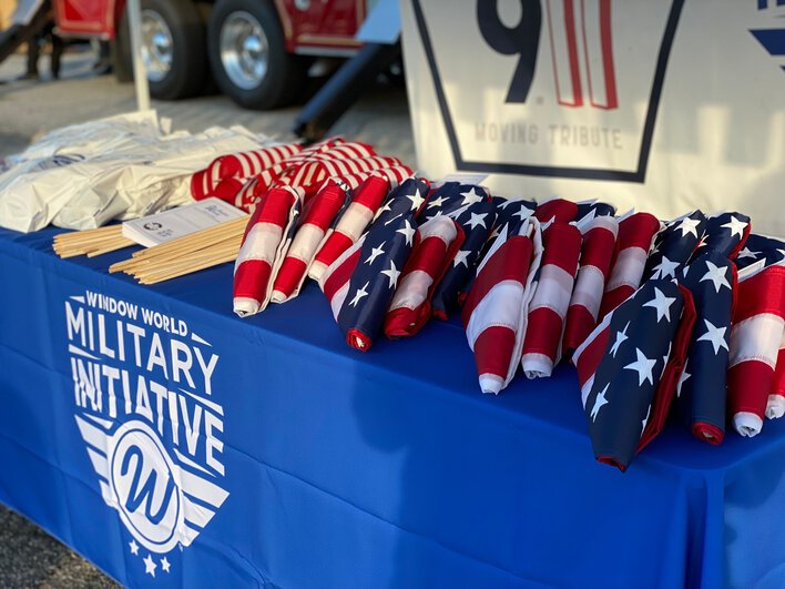 Close-up of a bunch of American flags on top of a table for Window World Military Initiative. 