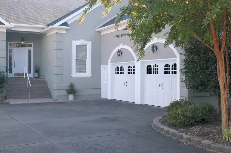 Home featuring white garage doors with arched windows.