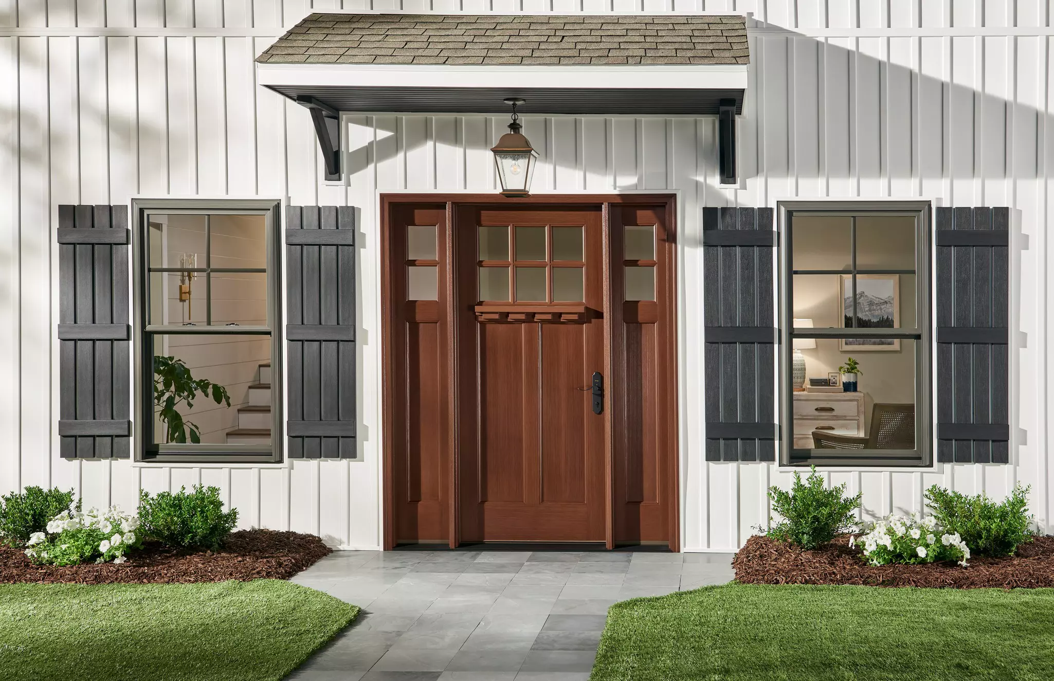 Exterior entry of a home with gray double-hung windows.