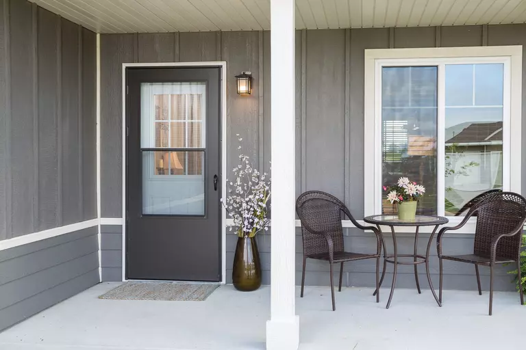 Gray house exterior with storm coastal doors.