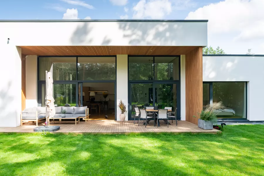An exterior of a modern home with large black-framed windows