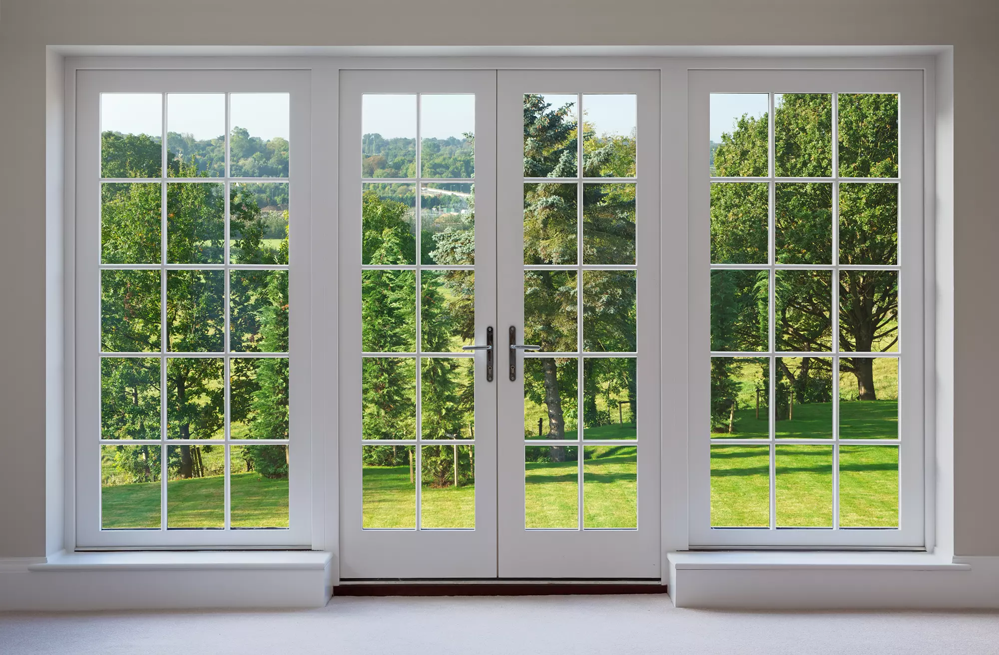 White French doors showing the trees and greenery outside.