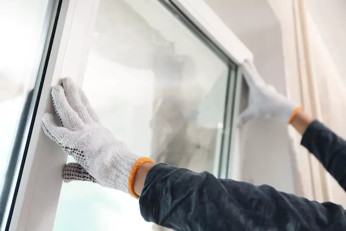Person replacing windows with energy-efficient ones