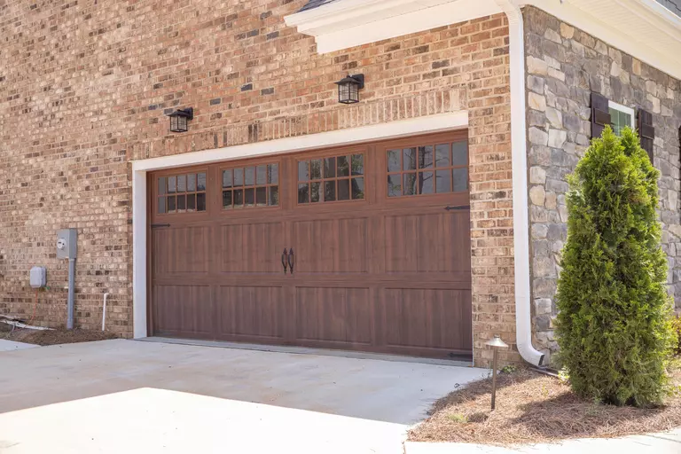 Brick exterior of a home with a wood-look garage door.
