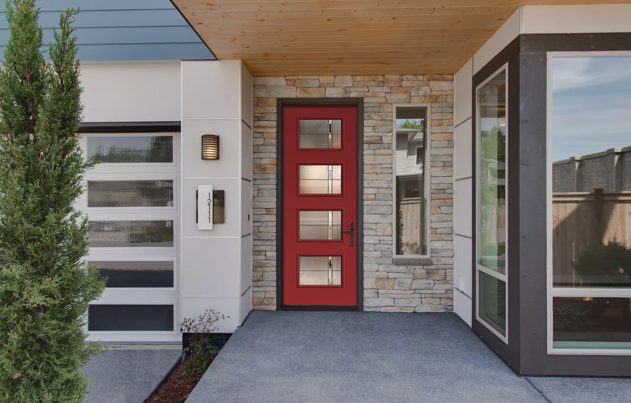 Modern home entry with a red front door and white windows.