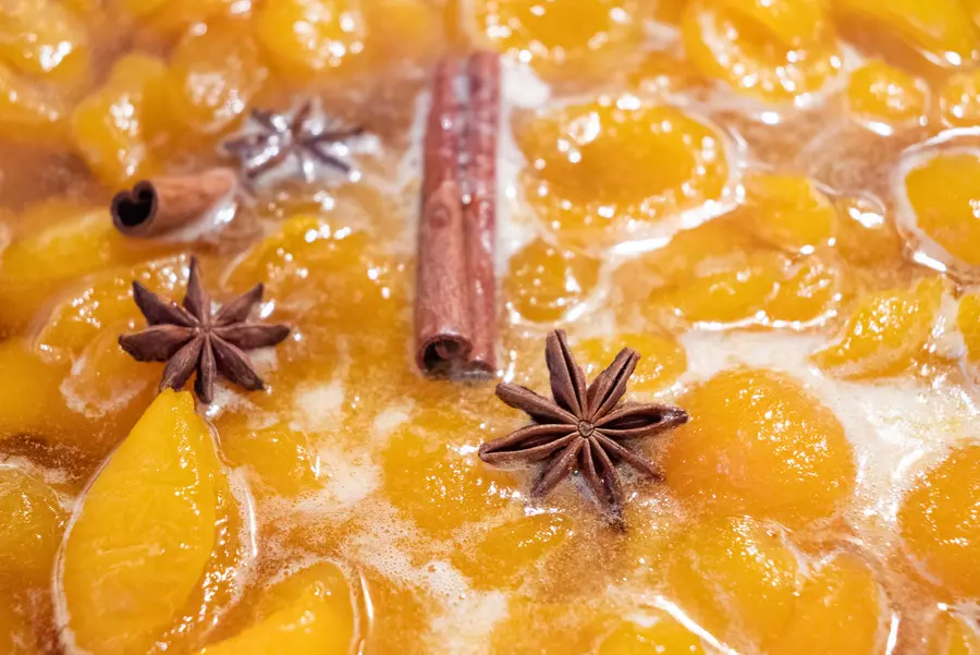 A holiday punch consisting of yellow fruit and cinnamon sticks