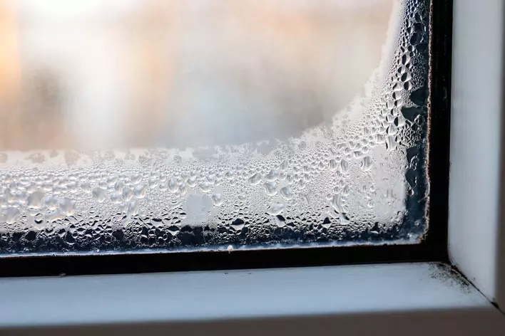 A multi-pane window with condensation inside indicating a leak has occurred.