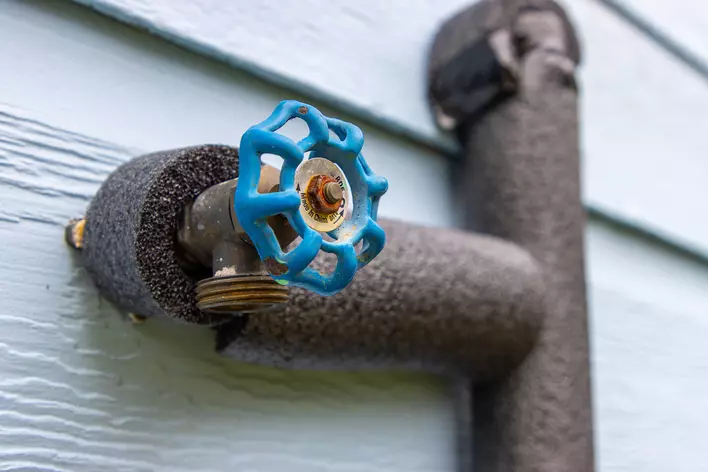 Insulated water line on the side of a house