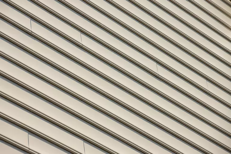 Close-up of tan colored composite siding on home exterior.