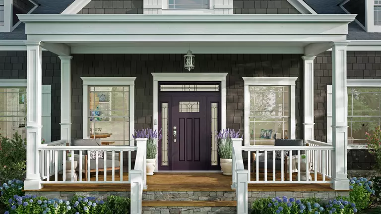 Purple front door on New England-style house with double-hung windows.