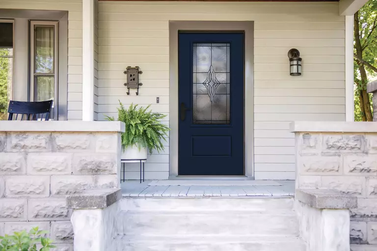 Front porch of a home with a dark entry door and decorative glass.
