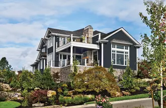Home with Alside ASCEND Composite Cladding in Glacier White, AMI 4000 Series Charter Oak Soffit in black and black 4000 Series Windows with Exterior Decorative Window Trim.