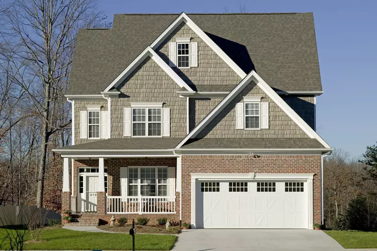 Three-story home with white windows, shutters, and doors.