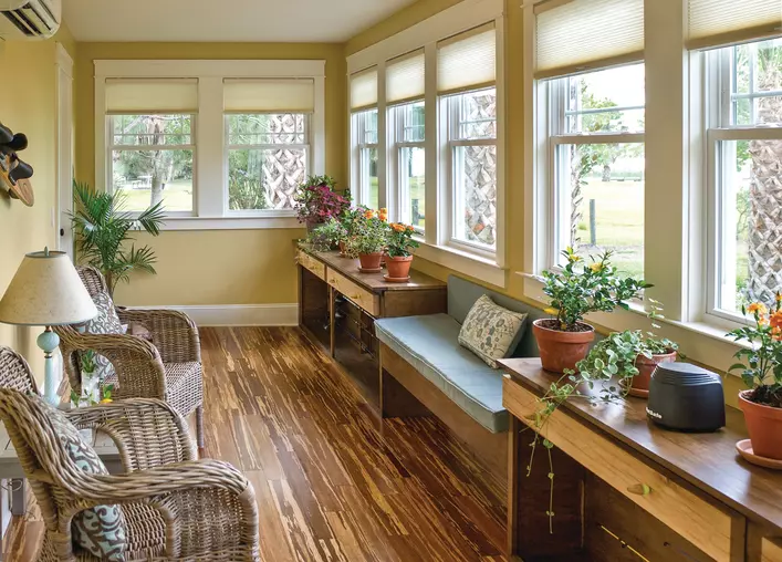 A sunroom full of double-hung windows, some of which won’t stay up and will need to be fixed.