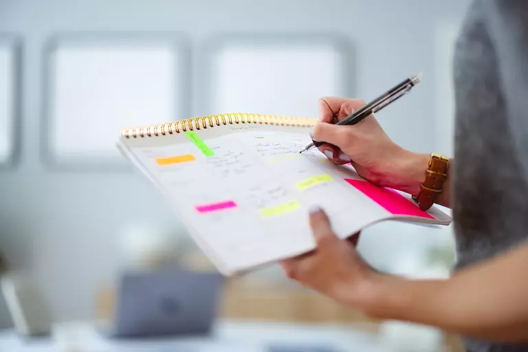 Woman making notes in a personal calendar.