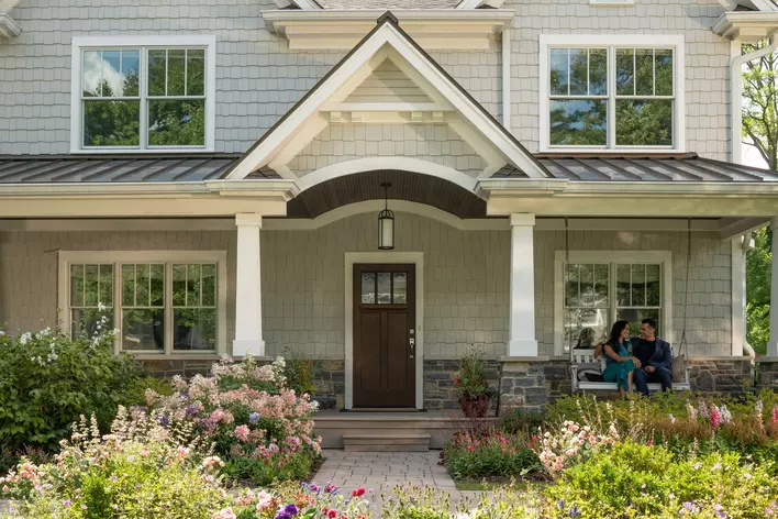 A front porch with a swing and energy-efficient entry door
