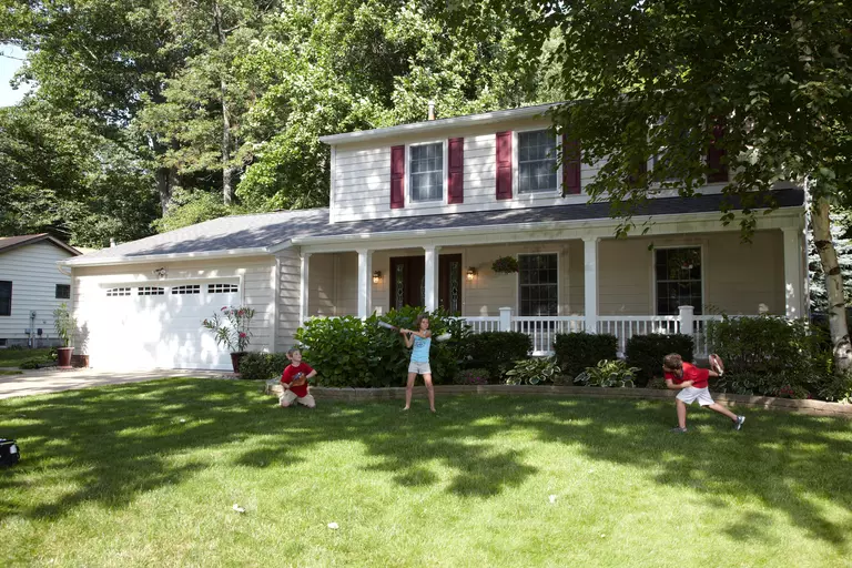 Kids playing in front of a house with new Everlast® composite siding.