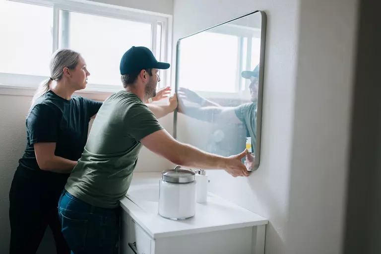 Woman and man renovating the bathroom of a home.
