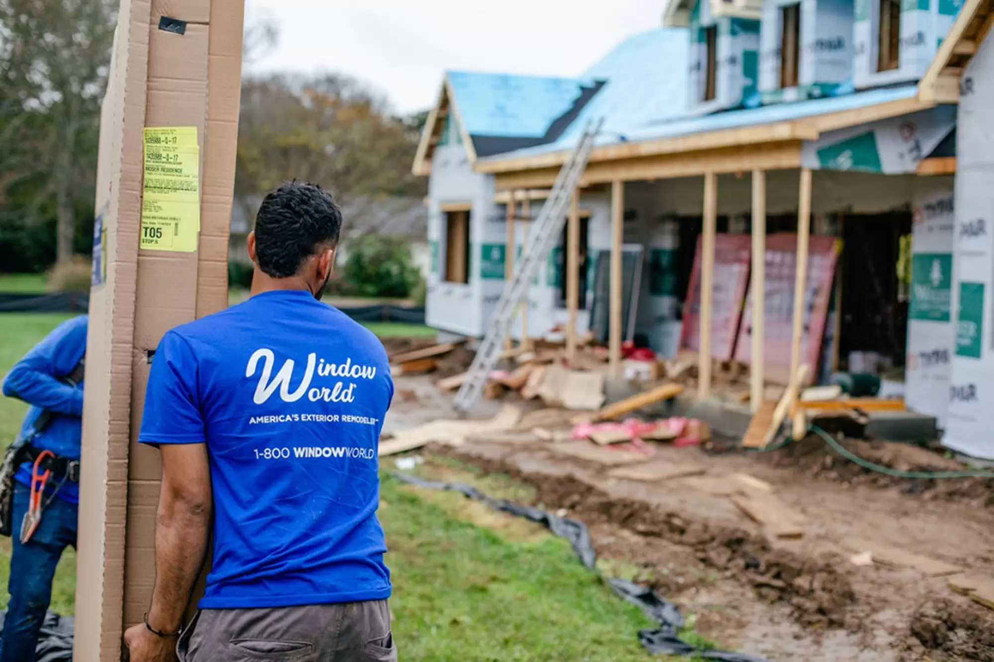Window World installation team carrying a new window to a home under construction.