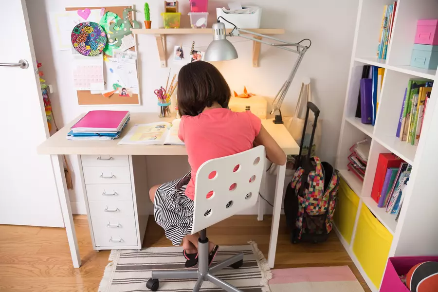 tween girl studying at a desk in her bedroom