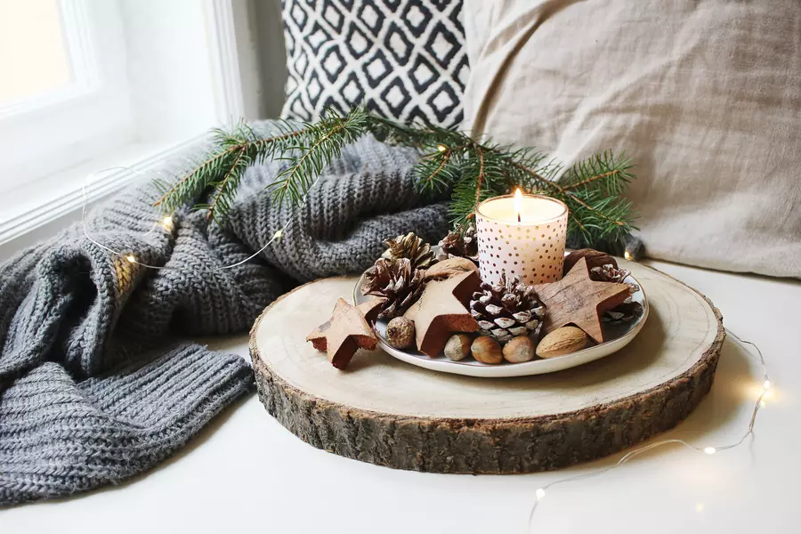 A window seat with a blanket, pillows, and various holiday decorations