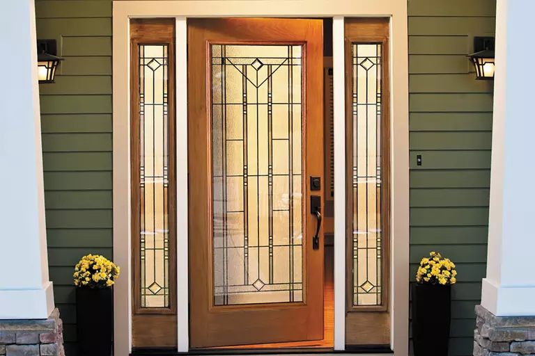 Craftsman house with a brown-colored front door and white columns in view.