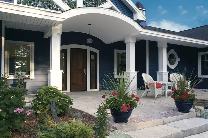 Front exterior of a home with blue vinyl siding and white trim