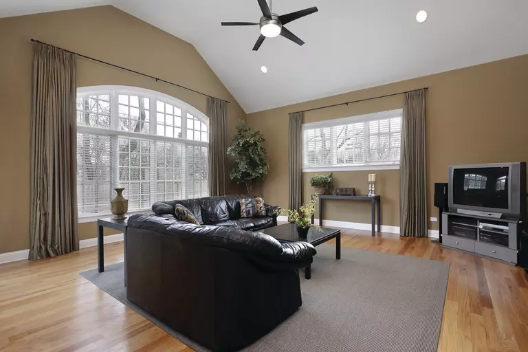 A brown living room with custom window shapes, using them to compliment the color of the space.