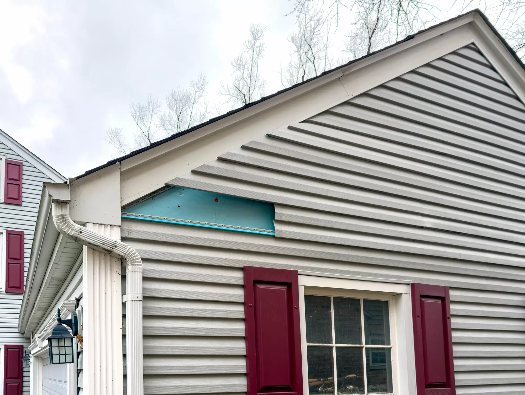 Home with a missing section of light-gray siding.