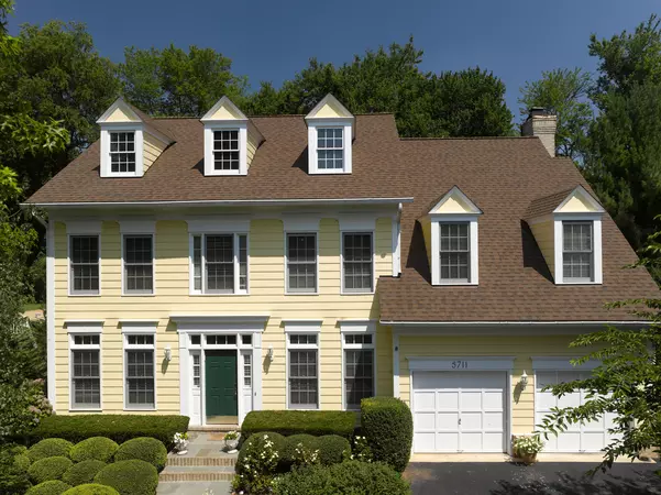 Large home with cream colored siding and Certainteed's Landmark shingle line in the color Heather Blend.