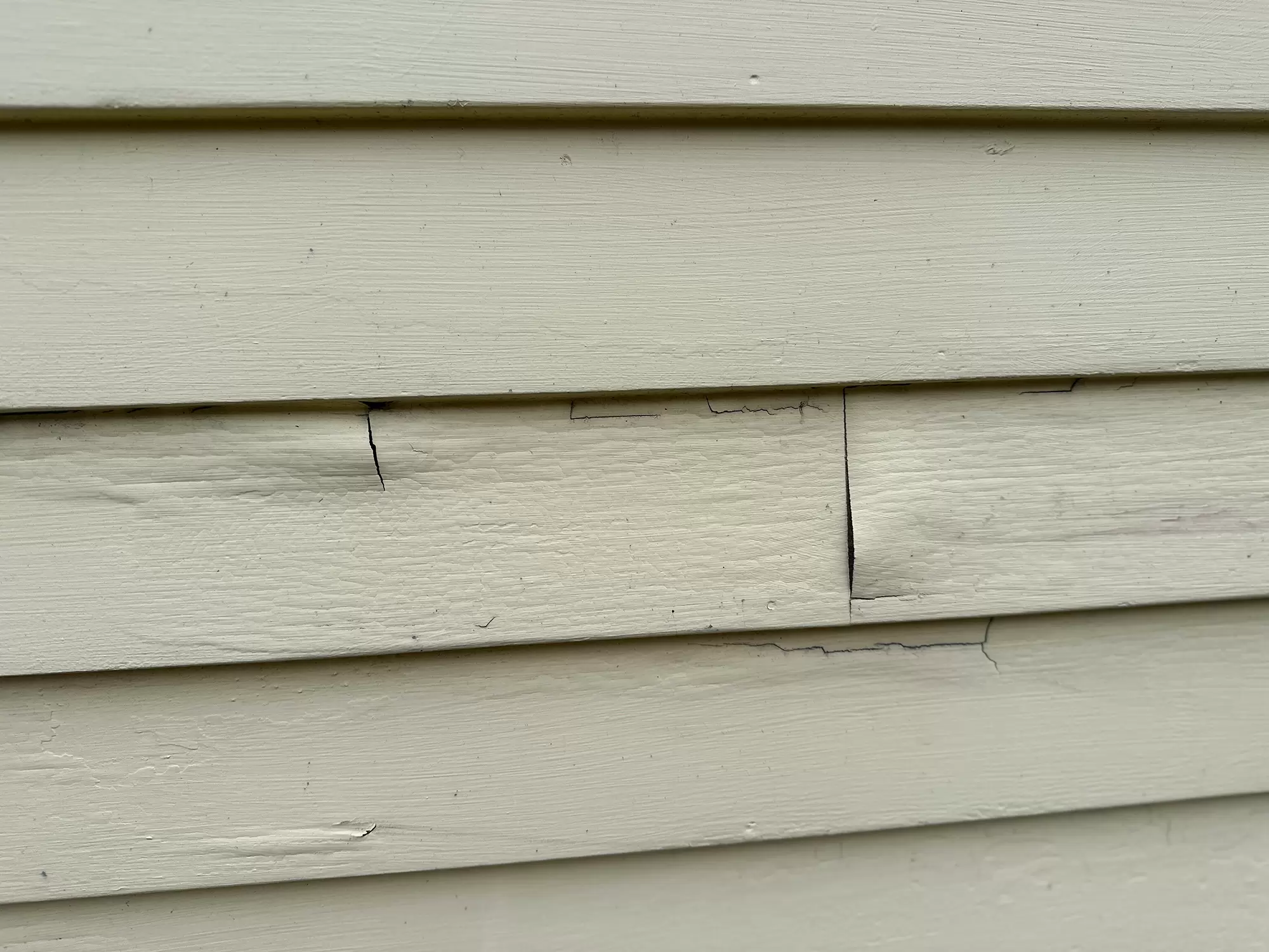 Close-up of siding with warping and cracking.