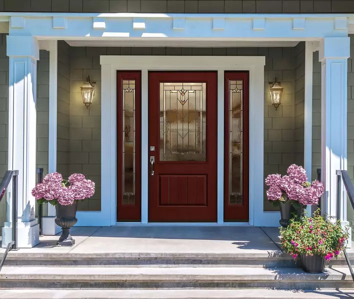 Wine-colored front door on a home with green siding