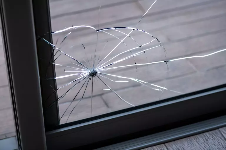 Damaged glass corner of a sliding glass patio door.
