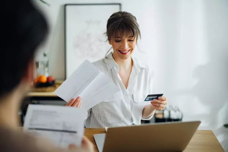 A man and woman happily looking through their home bills together.