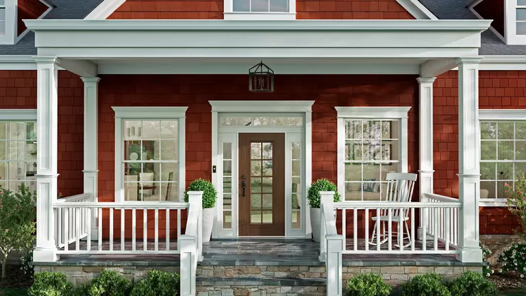Front porch of a home with a red exterior and white windows.